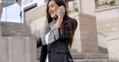 Image of Happy young woman chatting on her mobile
