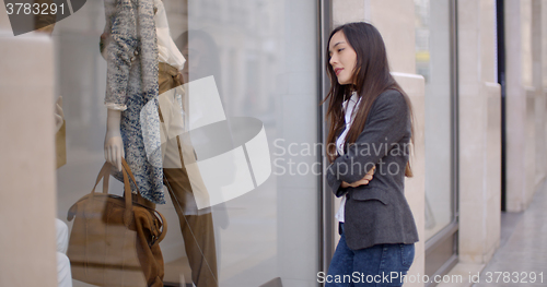 Image of Young woman looking at a shop mannequin
