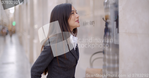 Image of Attractive young woman window shopping in town