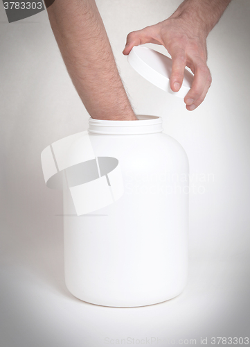 Image of Bodybuilding and Sports themehands holding a plastic jar with a 