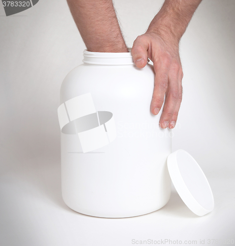 Image of Bodybuilding and Sports themehands holding a plastic jar with a 