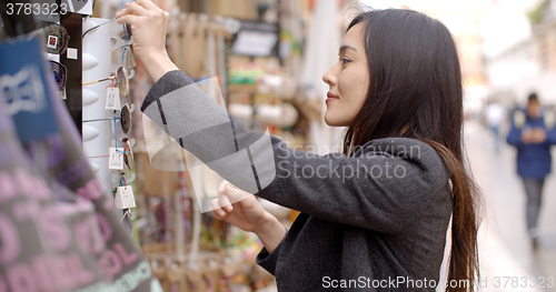 Image of Young woman shopping for sunglasses