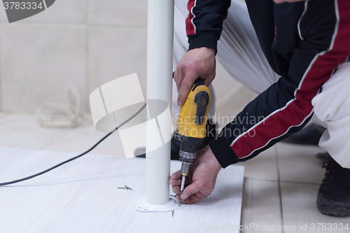 Image of repairman working with drilling machine