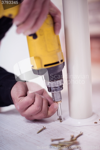 Image of repairman working with drilling machine