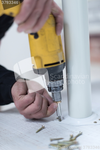 Image of repairman working with drilling machine