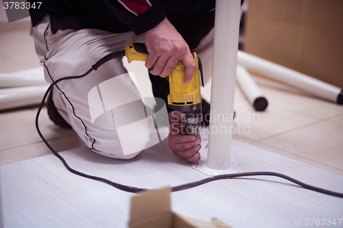 Image of repairman working with drilling machine