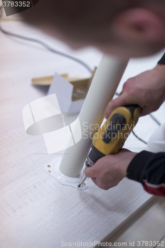 Image of repairman working with drilling machine