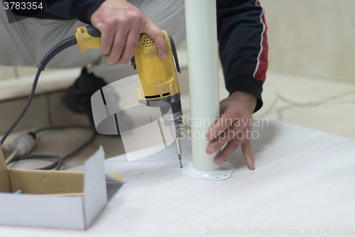 Image of repairman working with drilling machine