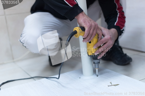 Image of repairman working with drilling machine