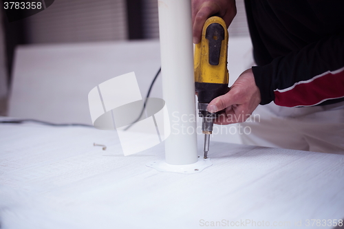 Image of repairman working with drilling machine