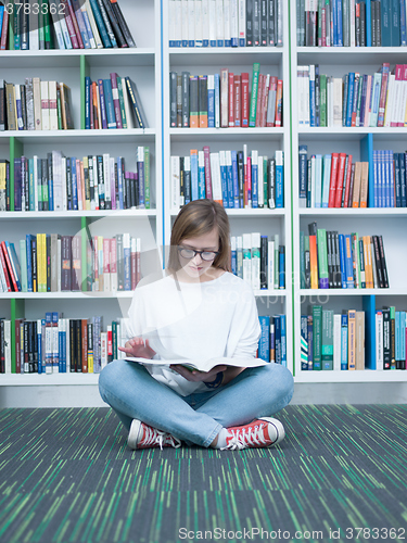 Image of student girl reading book in library