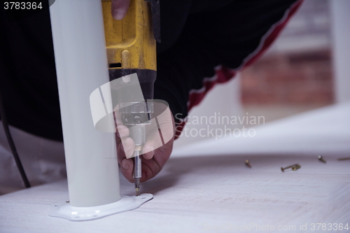 Image of repairman working with drilling machine