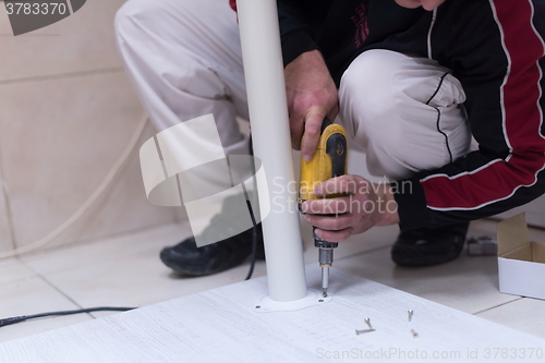 Image of repairman working with drilling machine