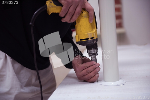 Image of repairman working with drilling machine