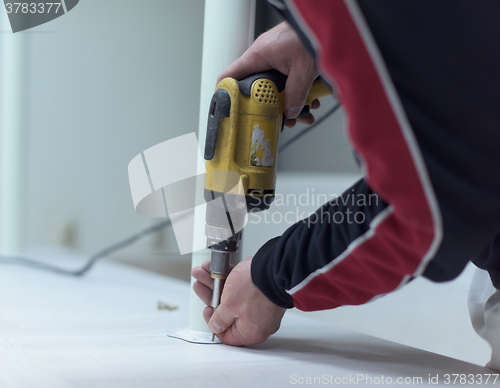 Image of repairman working with drilling machine