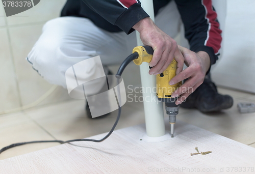 Image of repairman working with drilling machine