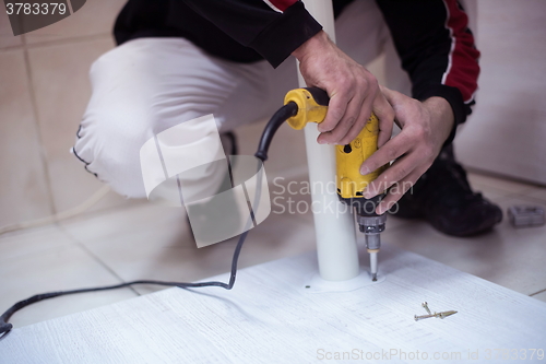 Image of repairman working with drilling machine