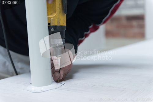 Image of repairman working with drilling machine