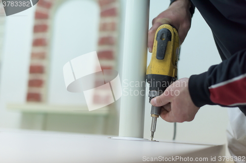 Image of repairman working with drilling machine