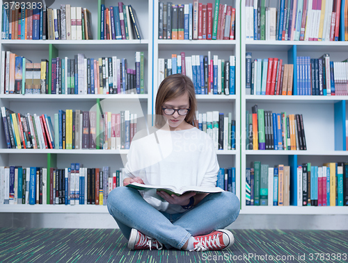 Image of student girl reading book in library