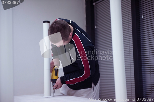 Image of repairman working with drilling machine