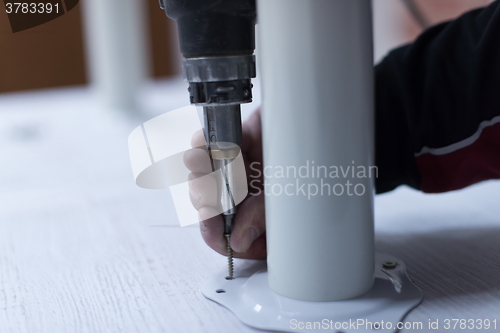 Image of repairman working with drilling machine