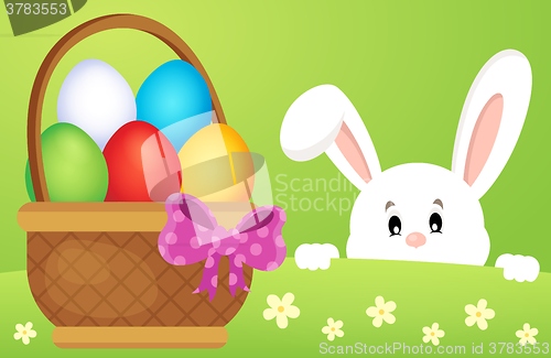 Image of Lurking Easter bunny by basket with eggs