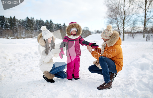 Image of happy family with child in winter clothes outdoors