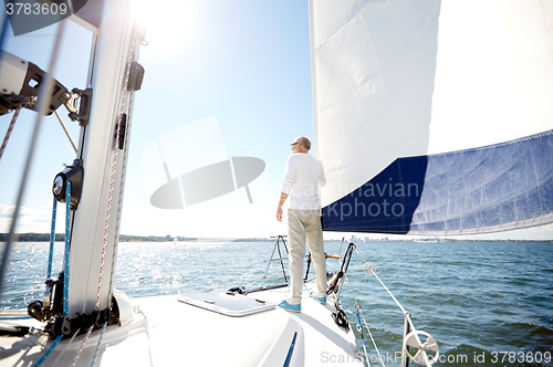 Image of senior man on sail boat or yacht sailing in sea