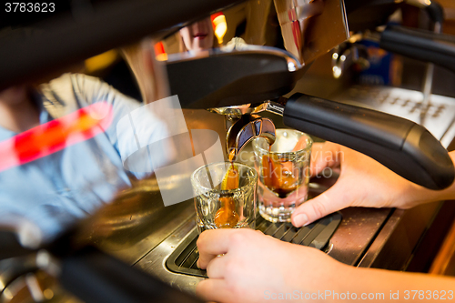 Image of close up of woman doing espresso by coffee machine