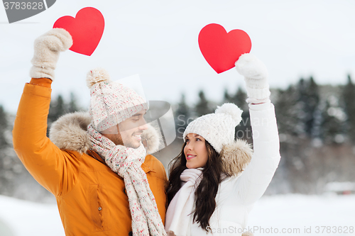 Image of happy couple with red hearts over winter landscape