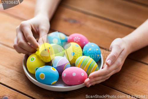 Image of close up of woman hands with colored easter eggs