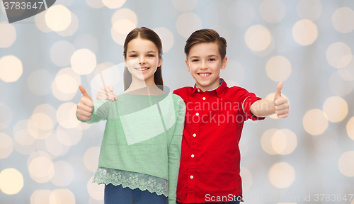 Image of happy boy and girl showing thumbs up