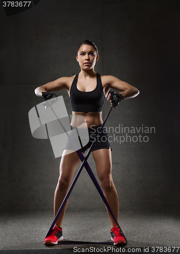 Image of woman with expander exercising in gym