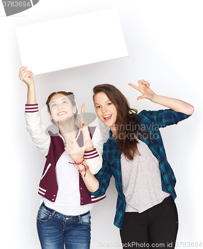 Image of smiling teenage girls holding white blank board