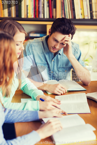 Image of students with books preparing to exam in library