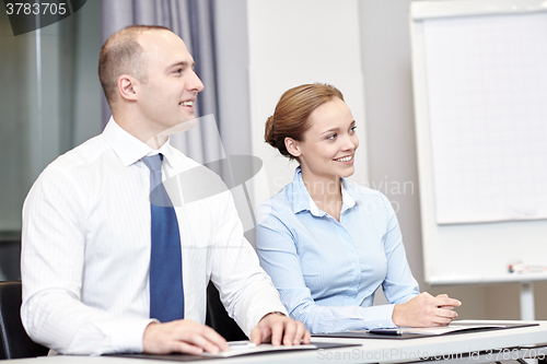 Image of group of smiling businesspeople meeting in office