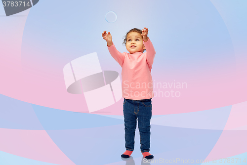 Image of little baby girl playing with soap bubble
