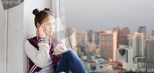 Image of teenage girl with smartphone and earphones