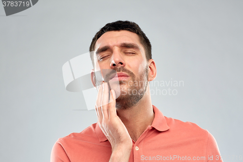 Image of unhappy man suffering from toothache