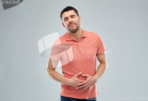 Image of unhappy man suffering from stomach ache