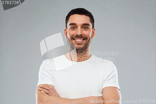 Image of smiling man with crossed arms over gray background