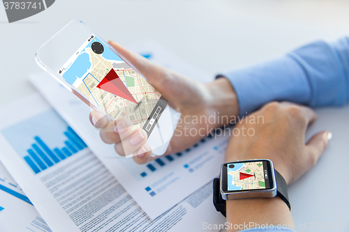 Image of hands with navigator map on smart phone and watch
