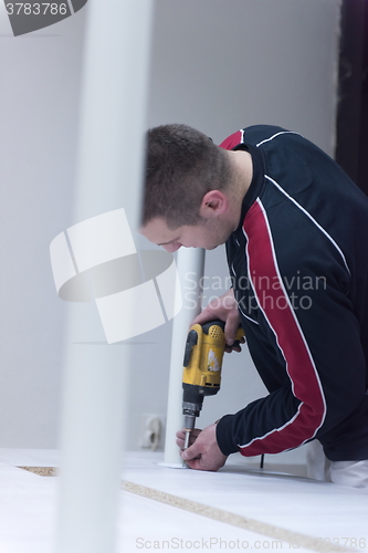 Image of repairman working with drilling machine