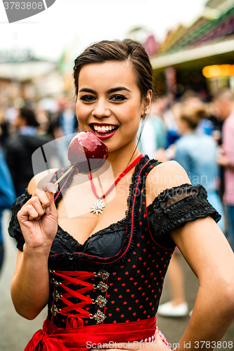 Image of Attractive young woman with love apple at the Oktoberfest