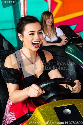 Image of Beautiful girls in an electric bumper car in amusement park