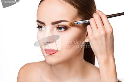 Image of Beautiful female eyes with bright blue make-up and brush