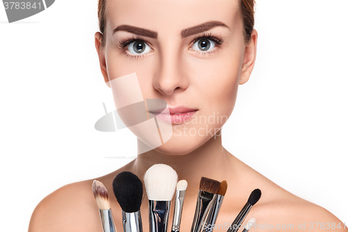 Image of Beautiful female eyes with bright blue make-up and brush