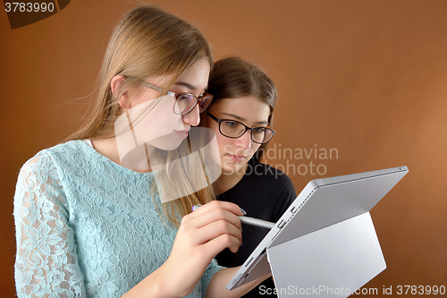 Image of two young teenage girls with a tablet