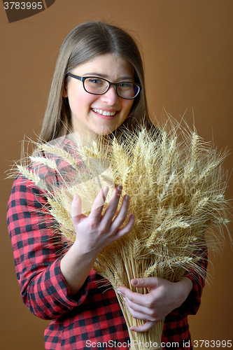 Image of girl hold in hand bunch of wheat stalks